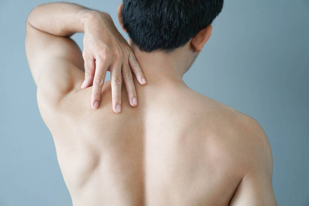 Крупним планом рука людини тримає плече з болем на синьому фоні, охороною здоров'я та медичною концепцією
 - Фото, зображення