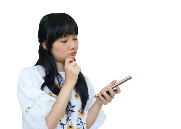 Aranyos ázsiai lány gondolkodás használata közben mobiltelefont - Fotó, kép