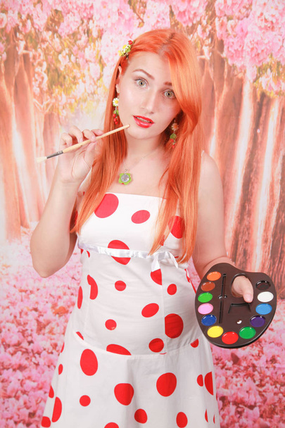 szép vörös hajú lány álló és gazdaság paletta színek - Fotó, kép