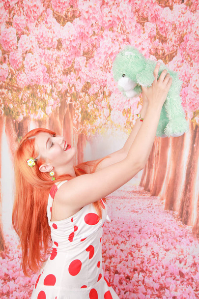 Kızıl saçlı mutlu kadın bir oyuncak ayı ve mutlu aldı - Fotoğraf, Görsel