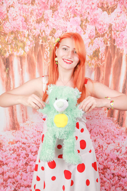 glückliche Frau mit roten Haaren erhielt einen Teddybär und glücklich - Foto, Bild
