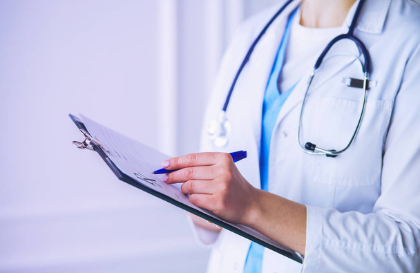 Woman doctor standing with folder at hospital - Foto, Imagem
