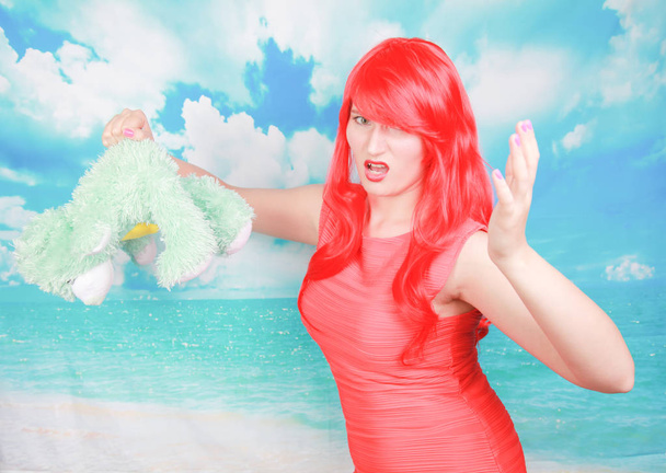 vörös hajú felnőtt nő büntetni kis aranyos mackó játék - Fotó, kép