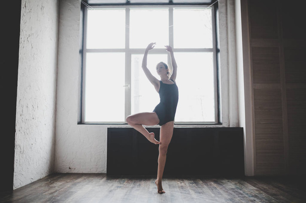 Plastizität schlanke Frau, die am Fenster tanzt. Profi-Tänzer tanzen gerne. Tänzerin trainiert modernes Ballett im Unterricht. zeitgenössischer Tanzkünstler. Tageslicht, Silhouette schöner Körper. Tanzthema - Foto, Bild