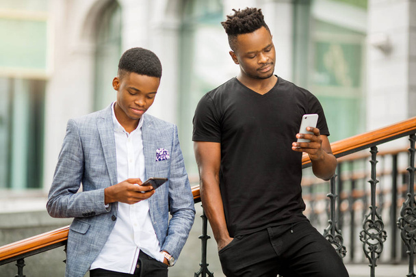two handsome adult men with phones in their hands - Zdjęcie, obraz