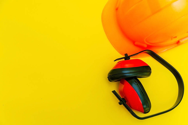 Beschermende uitrusting en gereedschap in een tas voor de bouwer op een gele achtergrond. - Foto, afbeelding