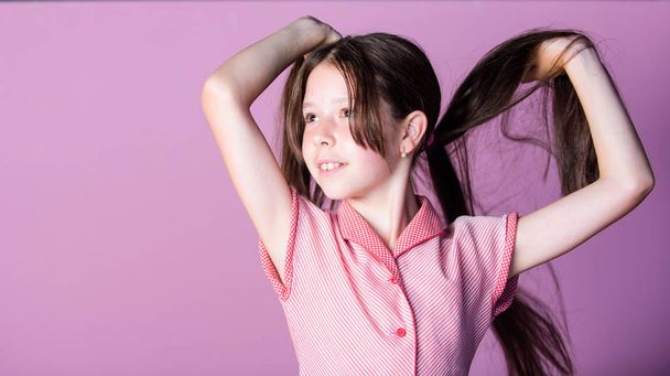 Happy childrens day. Pure beauty. Girl long healthy shiny hair close up. Little girl with long hair. Kid cute face with adorable hair on pink background. Beauty tips for tidy hair. Innocence concept - Foto, afbeelding