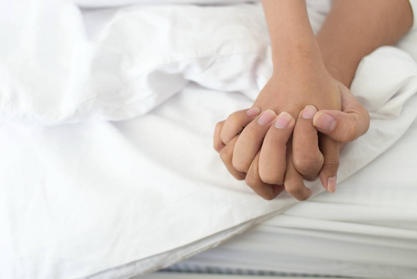 lähikuva pari kättä sängyssä
 - Valokuva, kuva