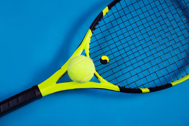 Tennis racket and ball sports on blue background - Фото, зображення