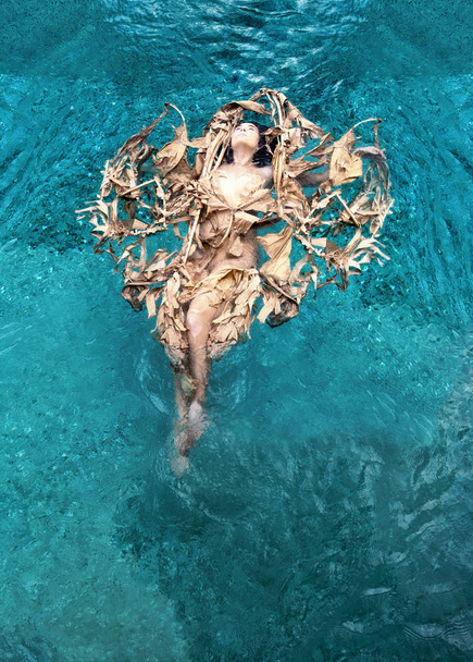 Vista superior de una hermosa mujer sexy con enfermedad de vitiligo y cabello oscuro relajado en hojas secas, de un plátano en forma de corazón flotando felizmente en agua turquesa en la piscina, espacio de copia
 - Foto, Imagen