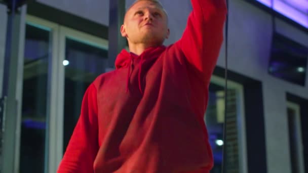 Hombre atlético con capucha roja en cuclillas
 - Metraje, vídeo