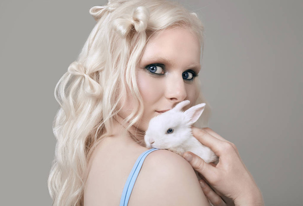 Albino fille blonde en robe élégante posant avec petit lapin mignon
 - Photo, image