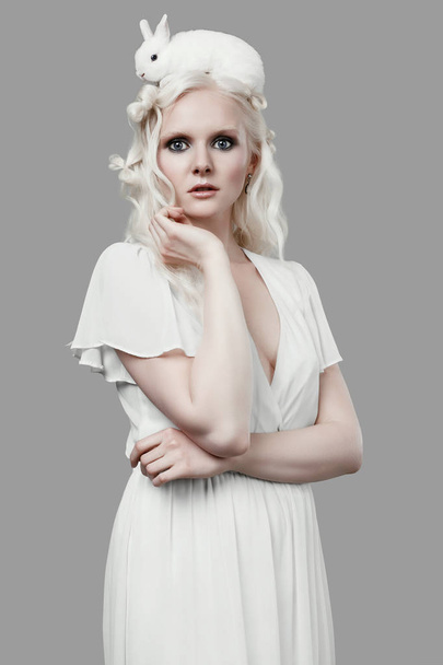 Chica rubia albino en vestido elegante posando con lindo conejito
 - Foto, Imagen