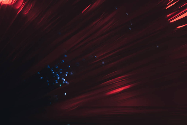 Mooie abstracte optische vezel lijn op een rode bokeh achtergrond. - Foto, afbeelding