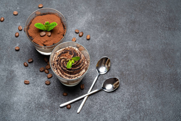 Classic tiramisu dessert in a glass cup on dark concrete background - Photo, Image