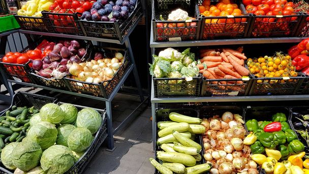 Bir müşteri tarafından satılık bir pazar tezgahında yatan sebze ve meyve çeşitli. Tarım ürünleri ticareti. Nitrat lar ve böcek ilaçları. Genetiği değiştirilmiş yiyecekler. Çiftlik meyveleri. Lif ve vitaminler - Fotoğraf, Görsel