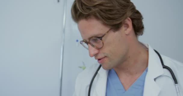Close-up of Caucasian male doctor talking with female patient in the ward at hospital. They are smiling  - Felvétel, videó
