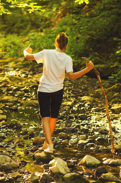 Девочка-подросток ходит по камням в ручье
 - Фото, изображение