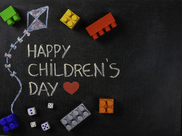Blackboard written Happy Children's Day and kite drawing with scattered assembly pieces. Copy space. - Photo, Image