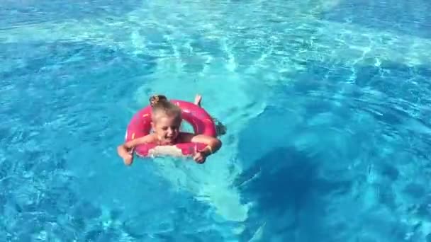 Child in the pool. A little girl is swimming in the pool. - Video