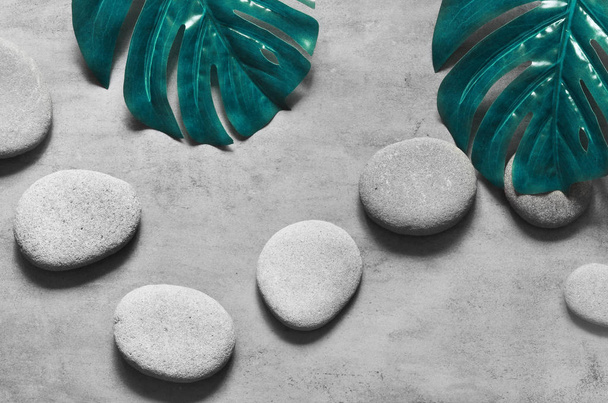 Flat lay composition with spa stones, palm leaves on grey background. - Foto, afbeelding