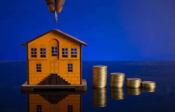 Pianificando di costruire la vostra casa dei sogni con calcolatrice e monete in miniatura a casa
 - Foto, immagini