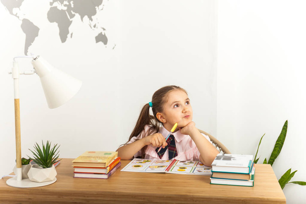 Girl studing at table on white background - Foto, afbeelding