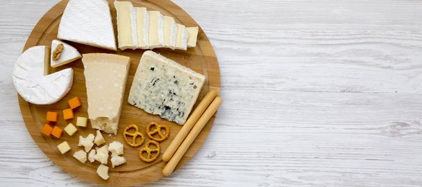 Tasting cheese with bread sticks, walnuts and pretzels on a bamb - Photo, Image