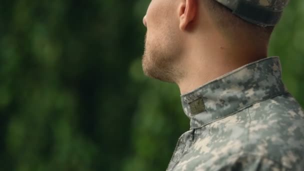 Young serviceman in uniform outdoors, enjoying rest in park, homecoming relax - Felvétel, videó