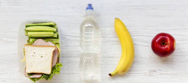 Almuerzo escolar saludable con sándwich, frutas y botella de wat
 - Foto, Imagen
