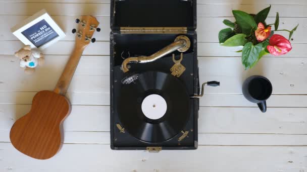 Top uitzicht op oude Gramophone spelen op witte houten tafel. Vinyl record spinnen op vintage draaitafel. Retro concept. Boven schot Slow Motion close-up - Video