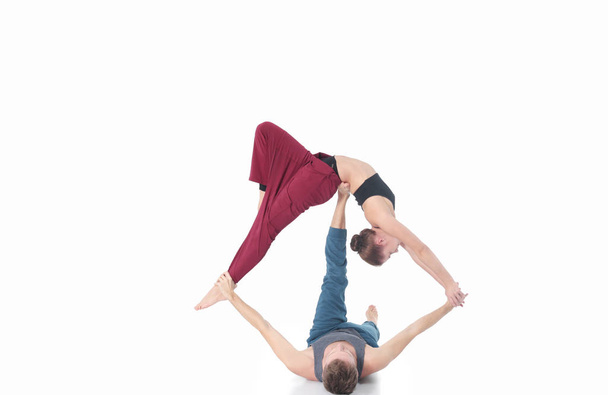 Young athletic couple practicing acroyoga. Balancing in pair. - Zdjęcie, obraz