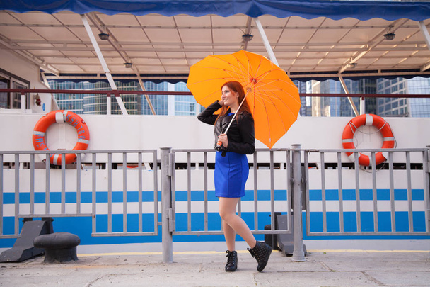 redheaded women under the orange heart shaped umbrella - Photo, Image