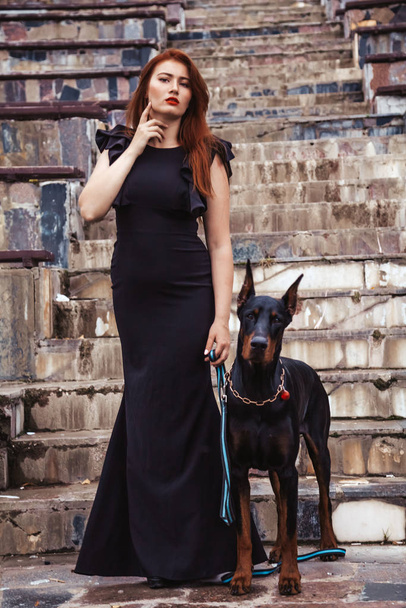 köpeği siyah doberman açık havada birlikte yürüyüş ile güzel kadın sahibi - Fotoğraf, Görsel