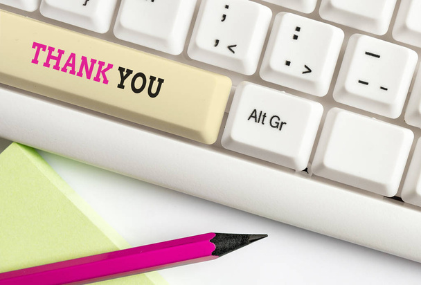 Word writing text thank you. Geschäftskonzept für einen höflichen Ausdruck, der bei der Anerkennung eines Geschenks oder einer Dienstleistung verwendet wird, weiße PC-Tastatur mit leerem Notizpapier über weißem Hintergrund. - Foto, Bild