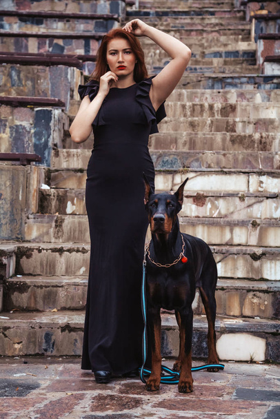 köpeği siyah doberman açık havada birlikte yürüyüş ile güzel kadın sahibi - Fotoğraf, Görsel