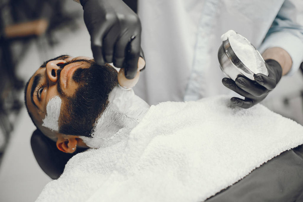 The man cuts his beard in the barbershop - 写真・画像