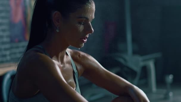 Beautiful Strong Fit Brunette in Sport Top and Shorts in a Loft Industrial Gym with Motivational Posters. She's Catching Her Breath after Intense Fitness Training Workout. Sweat All Over Her Face. - Кадры, видео