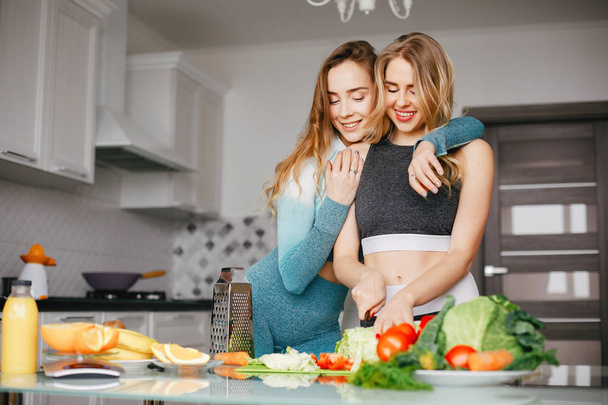 İki spor kız sebze ile mutfakta - Fotoğraf, Görsel