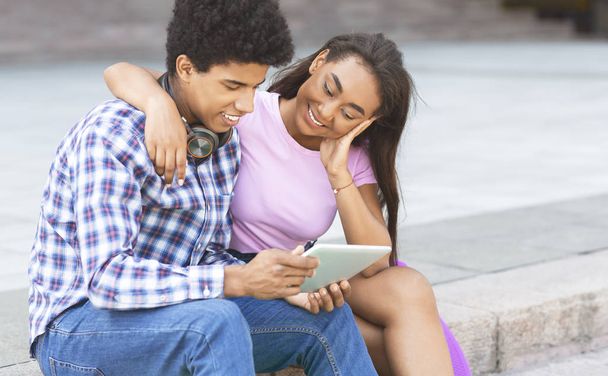 Smiling millennials reading electronic book on digital tablet together - Foto, Bild