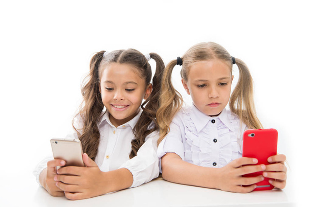 L'avenir est mobile. Petites filles utilisant des smartphones isolés sur blanc. Petits enfants ayant des leçons vidéo sur les téléphones mobiles. Préparer les élèves à la vie future. Carrière future avec compétences numériques. Avenir
 - Photo, image