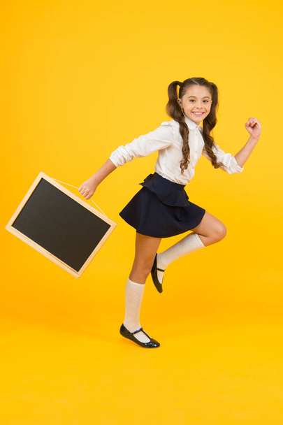 Follow me. Announcement and promotion. Girl school uniform hold blackboard going. Back to school concept. Making step. Schoolgirl pupil informing. School girl hold blank chalkboard copy space - Photo, image
