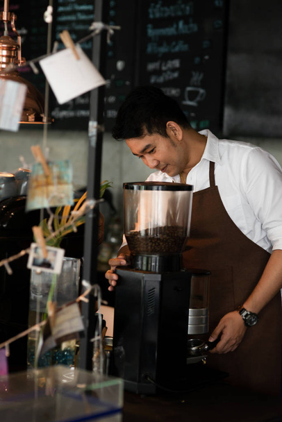 Happy Asian barista man working in cafe, lifestyle concept. - Photo, Image