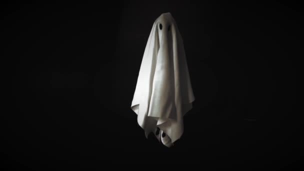 Filmación del disfraz de sábana blanca fantasma volando en el aire con fondo negro. Mínimo concepto de miedo de Halloween
. - Metraje, vídeo
