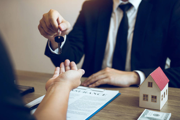 Hand of real estate agent passes the key to new homeowners in of - 写真・画像