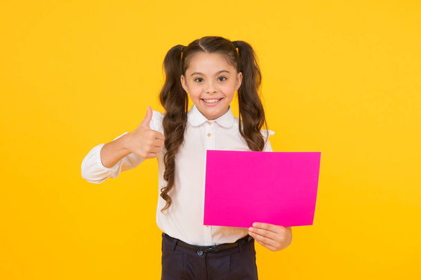 Your advertising gets thumbs up. Happy small child showing thumbs up for back to school advertising on yellow background. Little girl advertising product or event. Advertising education, copy space - Photo, image
