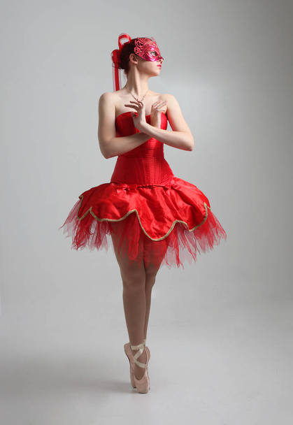 retrato de longitud completa de la niña con tutú bailarina roja y máscara. pose de baile contra un fondo de estudio
. - Foto, Imagen