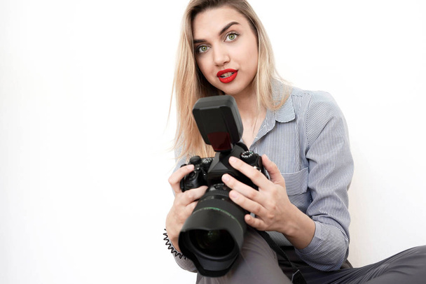 Beautiful young blonde with a big camera looks into the camera,  - Fotografie, Obrázek