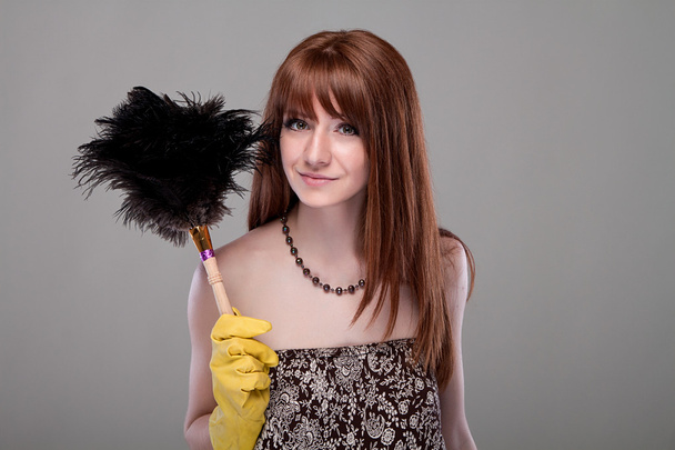 Attractive housewife with a brush to dust - Фото, зображення