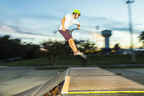 мальчик с удовольствием катается на самокате в скейт-парке
 - Фото, изображение